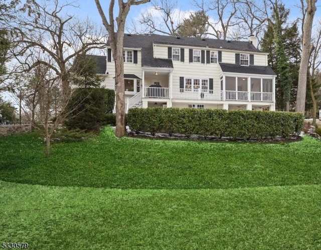 back of property featuring a yard and a sunroom