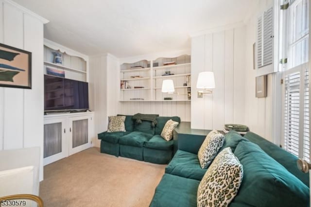 living room featuring ornamental molding, light colored carpet, and built in features