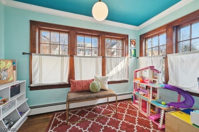 rec room with baseboard heating, wood finished floors, and crown molding