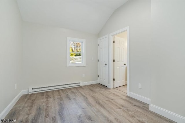 spare room with vaulted ceiling, light hardwood / wood-style flooring, and a baseboard radiator