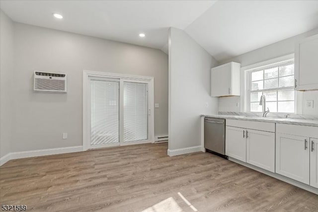 kitchen with sink, white cabinets, stainless steel dishwasher, and light wood-type flooring