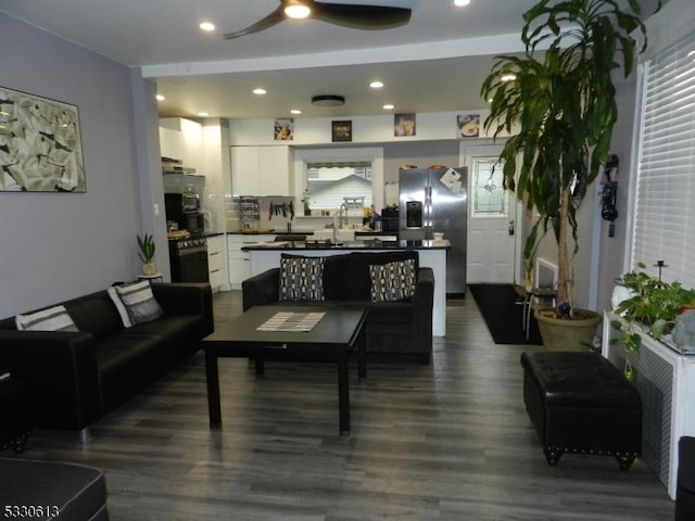 living room with ceiling fan, dark hardwood / wood-style flooring, and sink