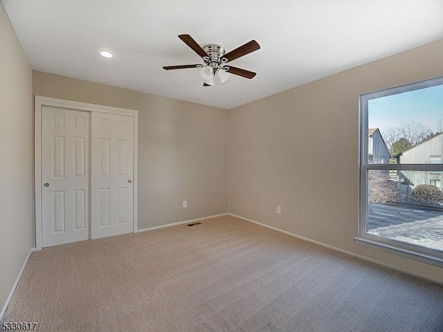 unfurnished bedroom featuring carpet flooring, ceiling fan, and multiple windows