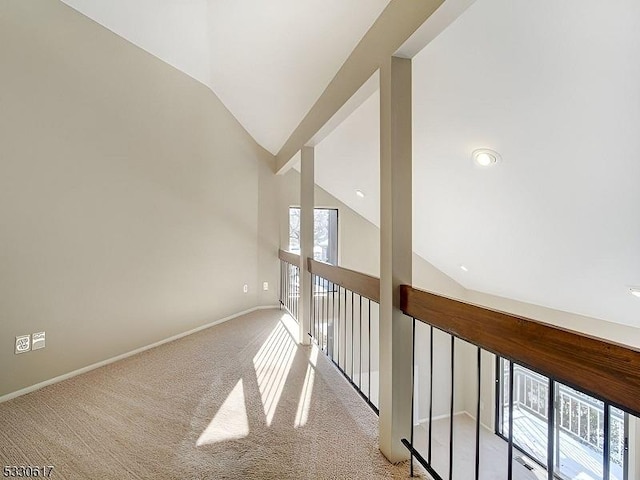 hall featuring light colored carpet and vaulted ceiling