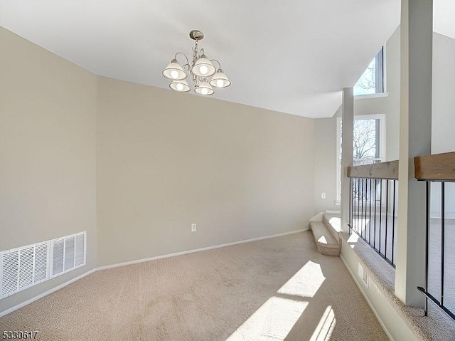 carpeted empty room featuring a notable chandelier and a high ceiling