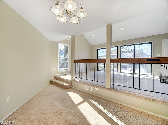 corridor with carpet flooring, lofted ceiling, and a chandelier