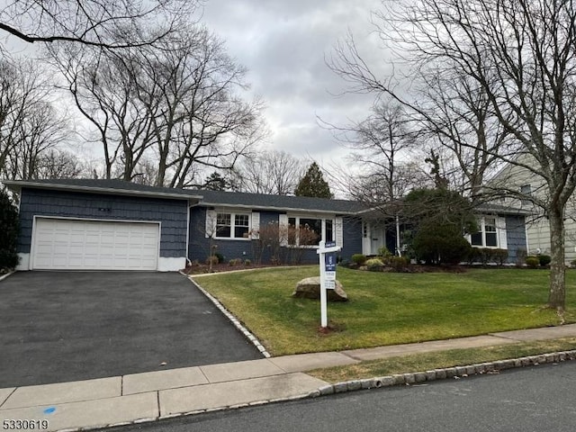 single story home with a garage and a front lawn