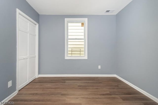 unfurnished bedroom featuring dark hardwood / wood-style floors and a closet