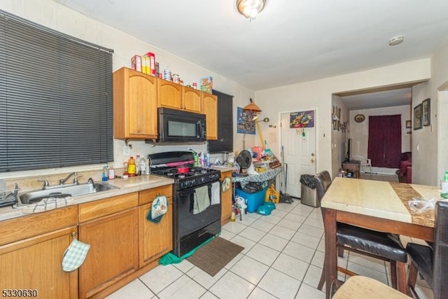 kitchen featuring black appliances, light tile patterned floors, and sink