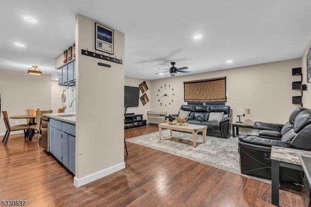 living room featuring ceiling fan and dark hardwood / wood-style flooring