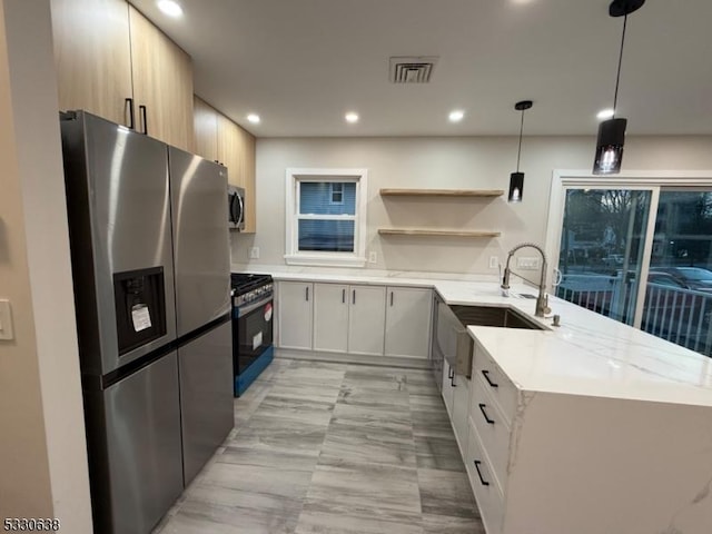 kitchen featuring kitchen peninsula, stainless steel appliances, white cabinetry, and hanging light fixtures