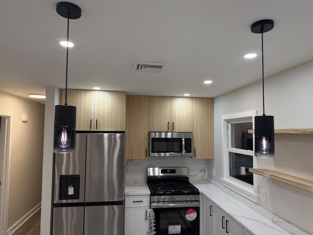 kitchen featuring pendant lighting, decorative backsplash, and stainless steel appliances