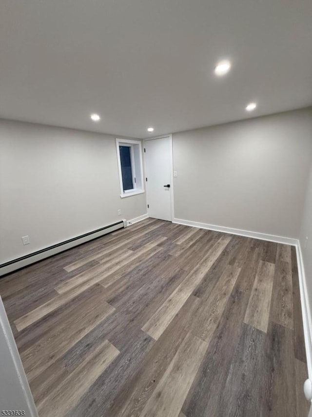 basement with hardwood / wood-style floors and a baseboard heating unit