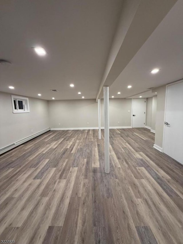 basement featuring hardwood / wood-style floors and a baseboard radiator