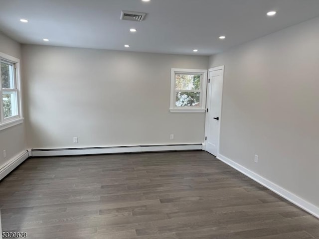 unfurnished room with a baseboard radiator and dark hardwood / wood-style floors