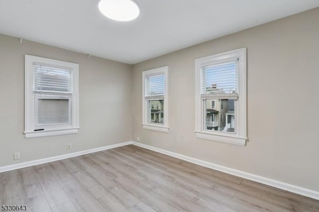 spare room featuring wood finished floors and baseboards