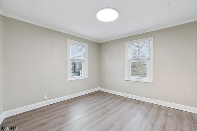 unfurnished room with ornamental molding, baseboards, and wood finished floors