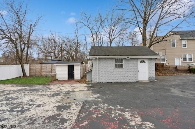 view of outbuilding featuring fence and an outbuilding