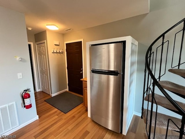 kitchen featuring stainless steel fridge and light hardwood / wood-style floors