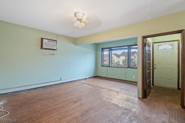 spare room featuring a wall unit AC, ceiling fan, hardwood / wood-style flooring, and a baseboard heating unit