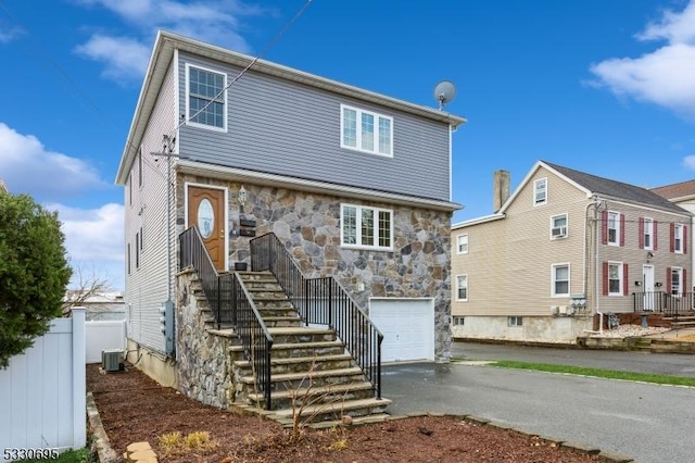 back of house featuring a garage and central air condition unit