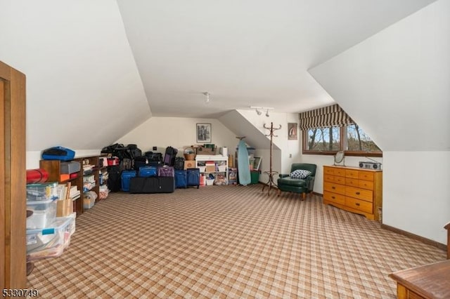 additional living space with light colored carpet and vaulted ceiling