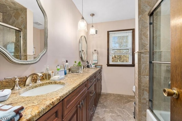 bathroom featuring combined bath / shower with glass door and vanity