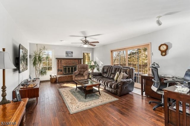 living room with ceiling fan, dark hardwood / wood-style floors, and a brick fireplace