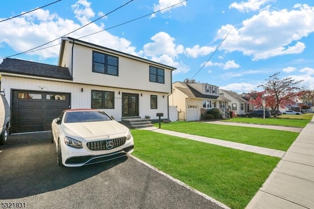 view of front of property with a front yard and a garage