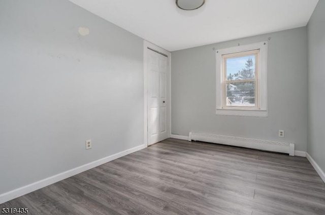 unfurnished room featuring light hardwood / wood-style floors and baseboard heating