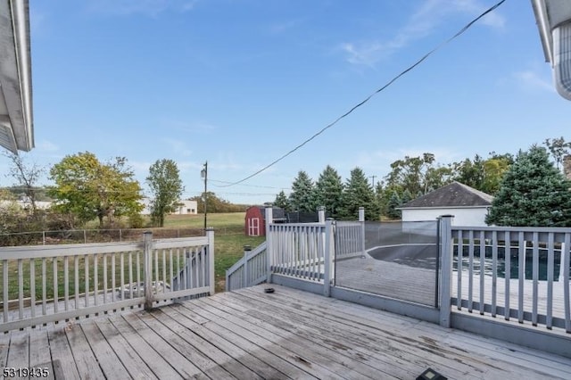 deck featuring a shed and a lawn