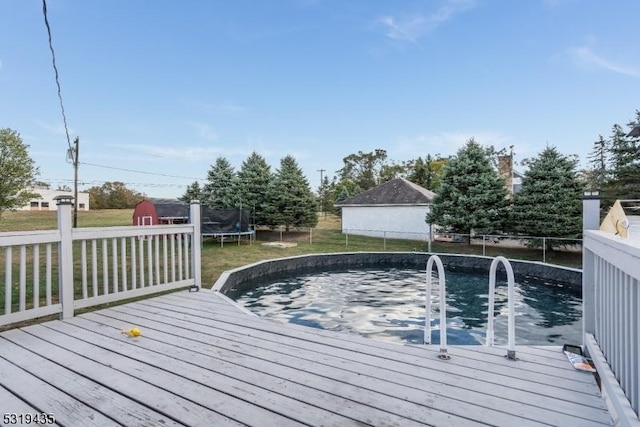 deck with a yard, a trampoline, and a shed