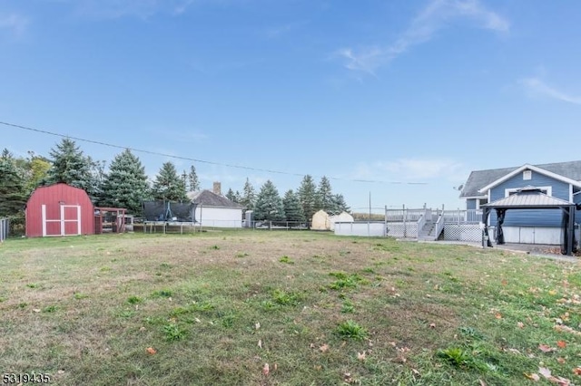 view of yard with a gazebo, a deck, and a trampoline