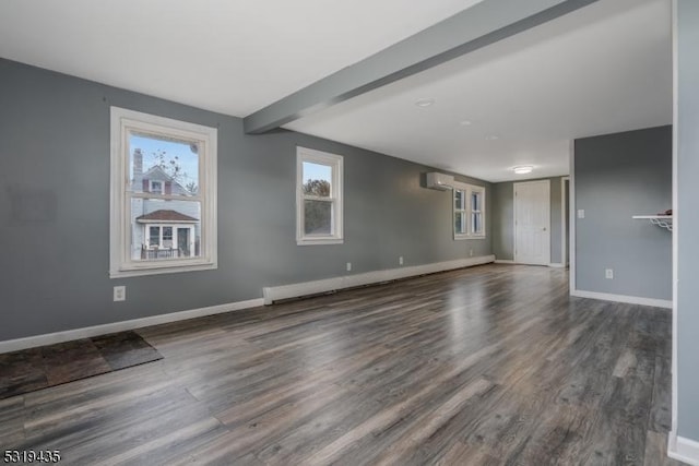 unfurnished room with beamed ceiling, baseboard heating, a wall unit AC, and dark wood-type flooring