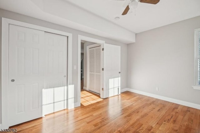 unfurnished bedroom with ceiling fan, a closet, and light hardwood / wood-style flooring