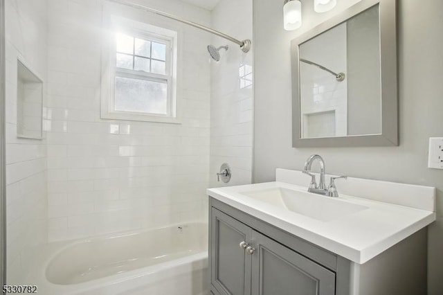 bathroom featuring tiled shower / bath and vanity