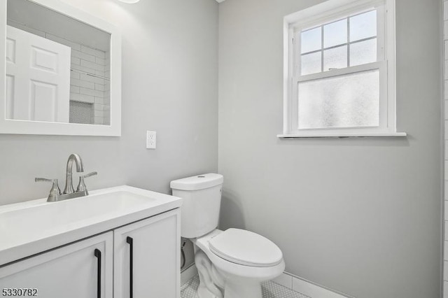 bathroom with toilet, vanity, and tile patterned flooring