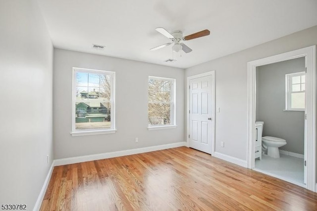 unfurnished bedroom with ceiling fan, a closet, light hardwood / wood-style floors, and ensuite bath