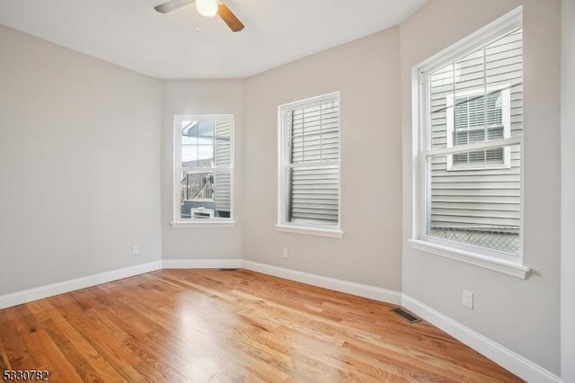 empty room with ceiling fan and light hardwood / wood-style floors