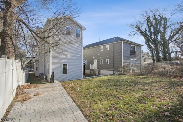 back of house with a patio area and a yard