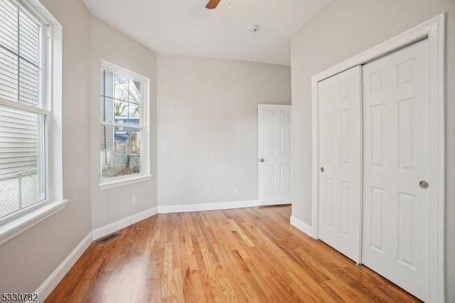 unfurnished bedroom with ceiling fan, light hardwood / wood-style floors, and a closet