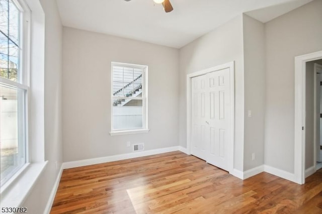 unfurnished bedroom with ceiling fan, a closet, and light hardwood / wood-style flooring