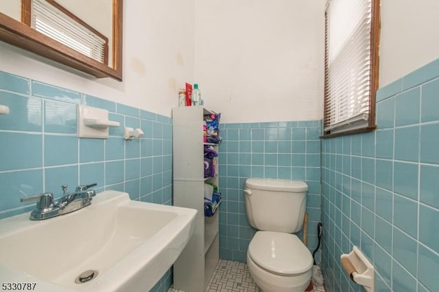 bathroom featuring tile patterned floors, sink, tile walls, and toilet