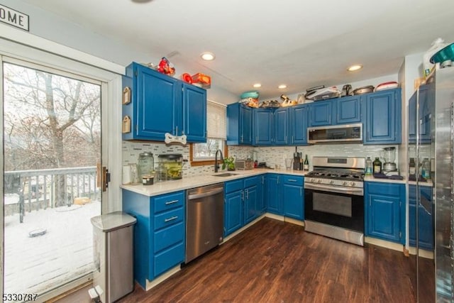 kitchen with blue cabinetry, dark hardwood / wood-style flooring, sink, and appliances with stainless steel finishes