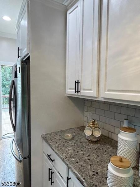 clothes washing area with cabinets and ornamental molding