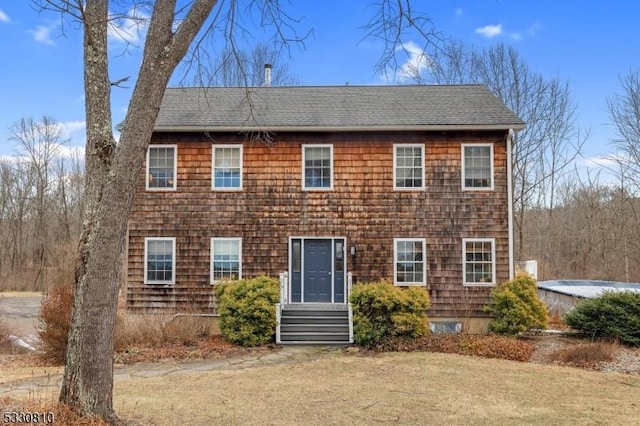 colonial inspired home featuring a front lawn