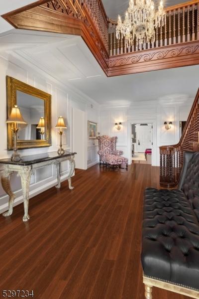 interior space featuring crown molding, wood-type flooring, and an inviting chandelier