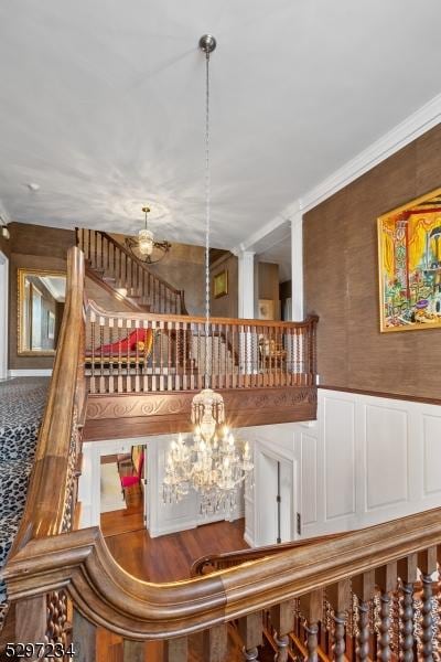 stairs with a notable chandelier and crown molding