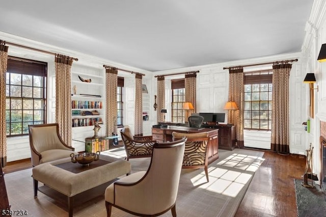 living area with built in features, crown molding, and dark wood-type flooring