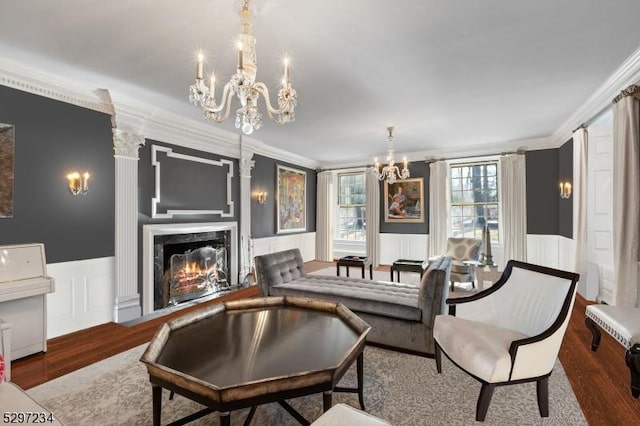 living room featuring a chandelier, hardwood / wood-style flooring, crown molding, and a premium fireplace